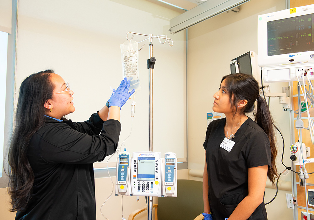 WP student Chrystell Huyhua '26 is instructed by Kristen Ann Uri '19.